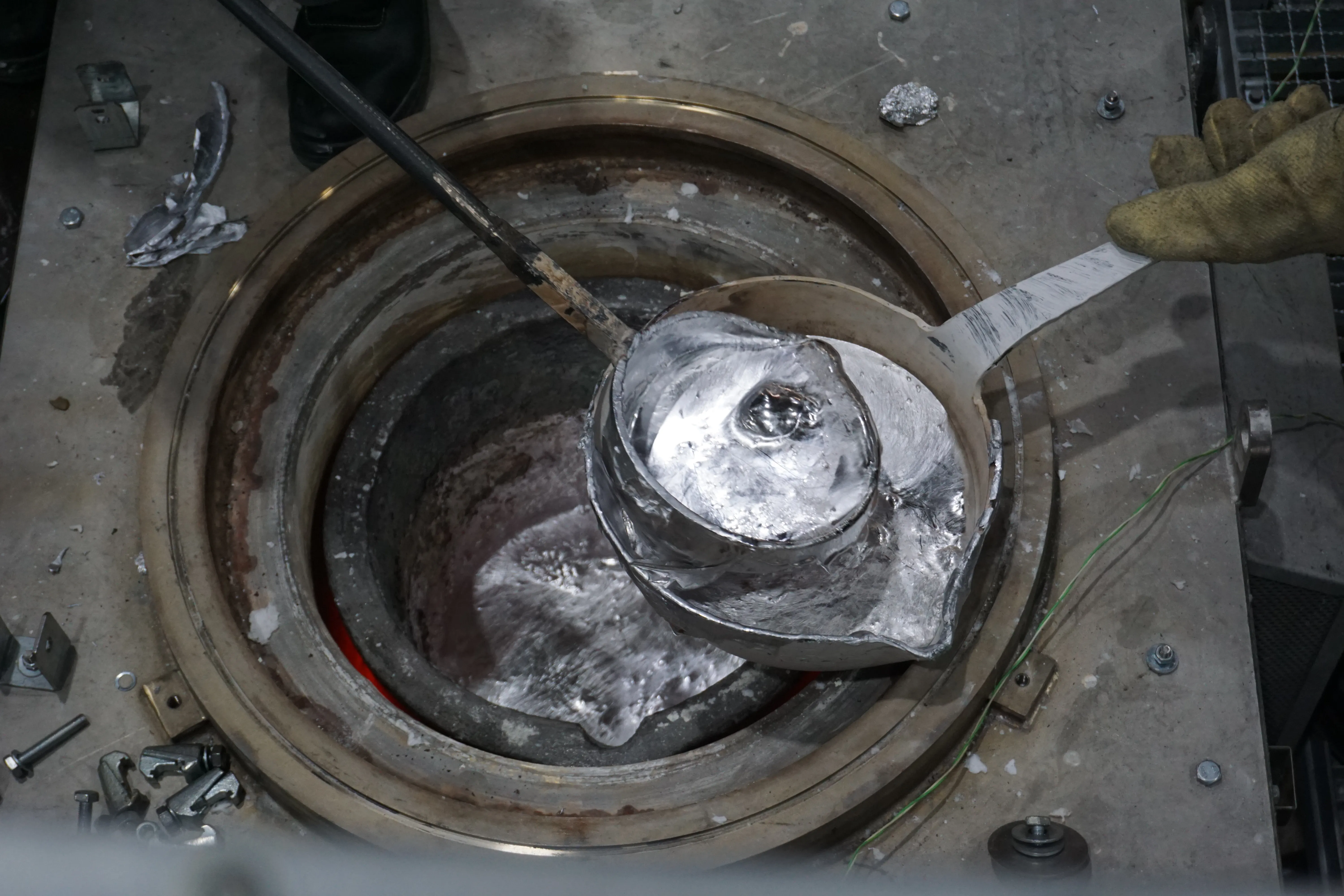 AMC-Schmelze wird mit Gießlöffel geschöpft